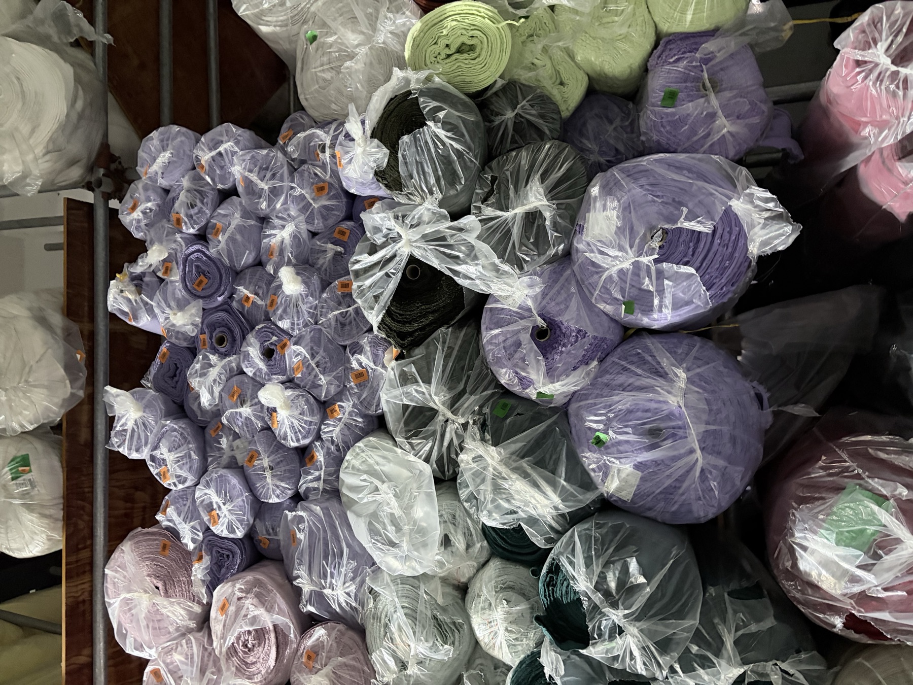 Purple, green and neutral surplus fabric rolls in our Beilun warehouse