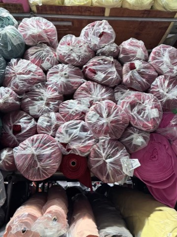 Red surplus fabric rolls in warehouse storage